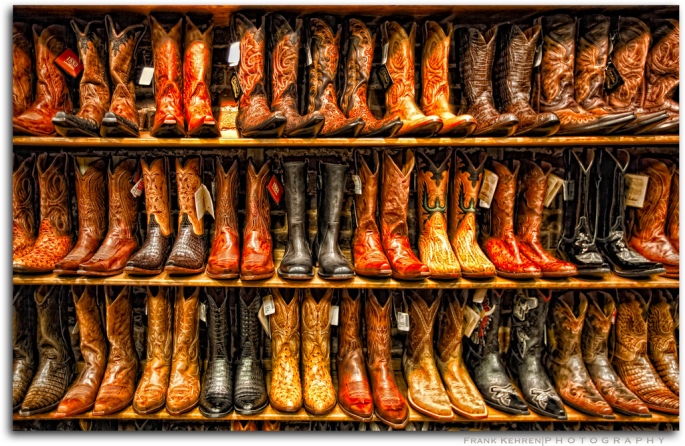 three shelves lined with cowboy boots